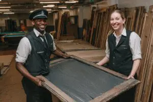 Movers easily carrying a piece of a pool table, showing how to get rid of a pool table
