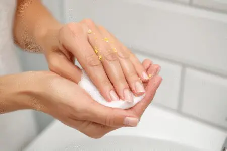 One of the top ways to learn how to get spray foam off hands safely and fast, showing oil being used to dissolve the residue
