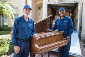 Professional movers moving a piano, a guide for how to get rid of a piano hassle-free