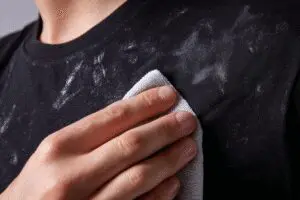 Top tips on how to get deodorant stains out of black shirts, demonstrating a simple removal technique on a t-shirt