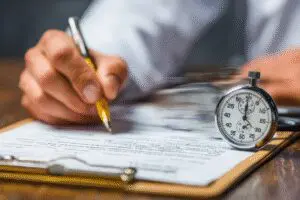 A doctor writing a note next to a speeding stopwatch, a guide on how to get a doctor's note for work fast