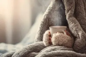 A guide for urgent relief on how to get rid of cotton fever fast, showing a person finding warmth and comfort in a blanket