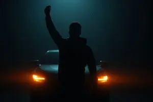 A person alone holding a car key, a metaphor for how to get a car with no credit or cosigner.