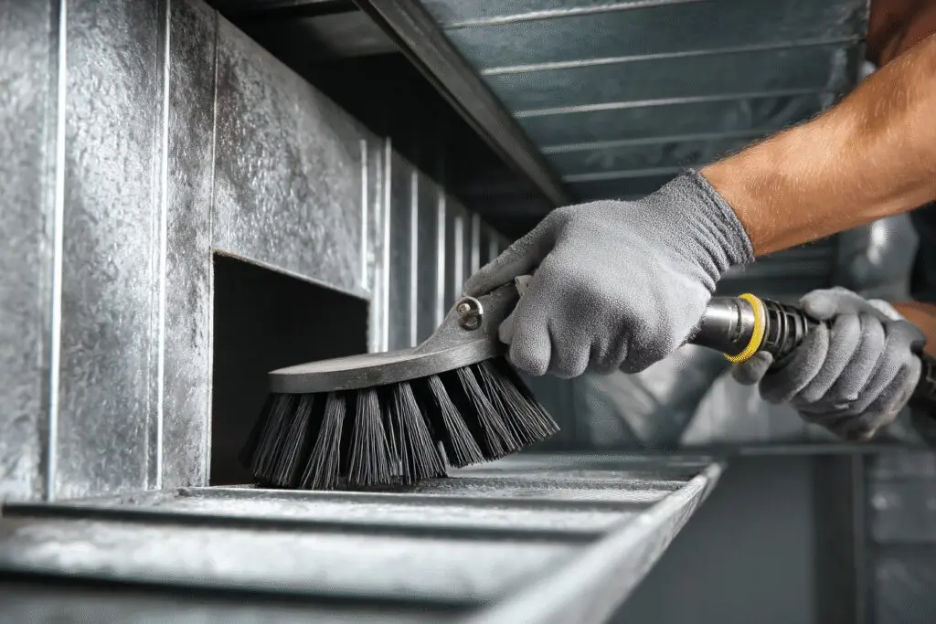 A professional solution for the FAQ on how to get rid of mold in air ducts, showing a technician cleaning inside a vent.