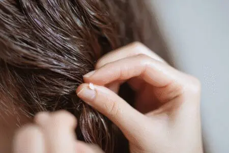 An easy trick for how to get super glue out of hair safely, showing oil being used to gently dissolve the glue