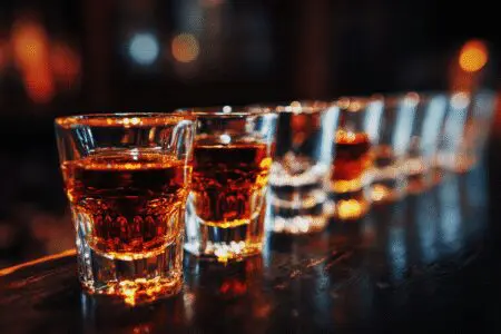 The truth revealed about how many shots it takes to get drunk, represented by a row of filled and empty shot glasses